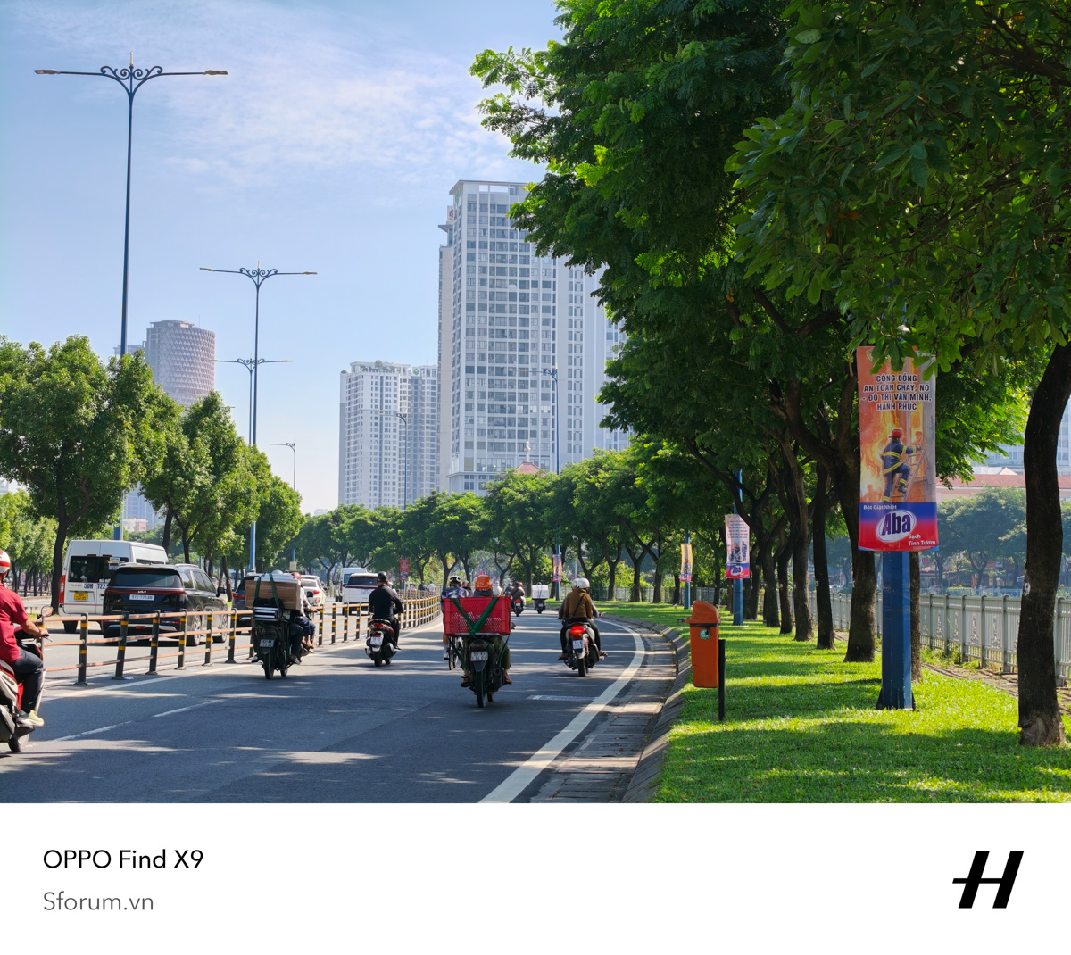 OPPO Find X9 ghi lại hình ảnh đường phố đô thị Việt Nam rợp cây xanh, xe máy lưu thông dưới ánh nắng với các tòa nhà cao tầng phía xa